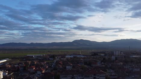 Beautiful-establishing-drone-shot-footage---flying-over-the-typical-Bulgarian-small-town,-Sopot,looking-towards-'Sredna-gora'-mountain-and-the-fields-before-it