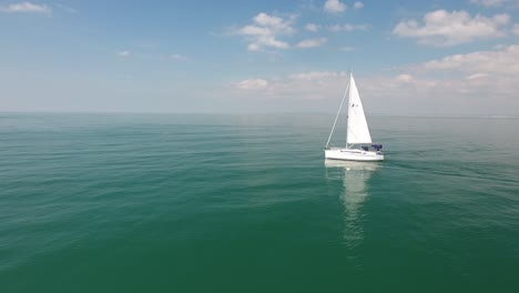 Fix-Drone-shot-with-sailboat-passing-in-mediterranean-sea.-Beautiful-sunny