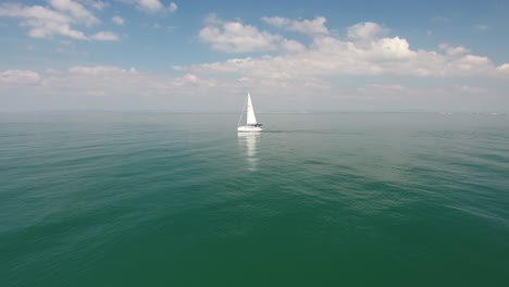 Drone-shot-flying-towards-a-sailboat-over-mediterranean-sea.-Beautiful-sunny