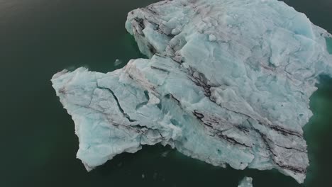 Aerial-drone-shot-an-iceberg-in-Jokulsarlon-Iceland's-most-famous-glacier-lagoon