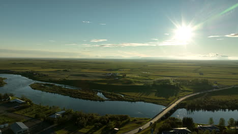 Die-Sonne-Scheint-In-Hella-über-Einer-Brücke-Und-Dem-Fluss-Ytri-Rangá,-Island-Luftaufnahme