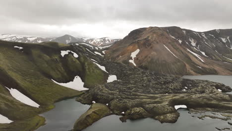 Different-colourful-volcanic-mountains-along-a-lake-in-Landmannalaugar-Iceland