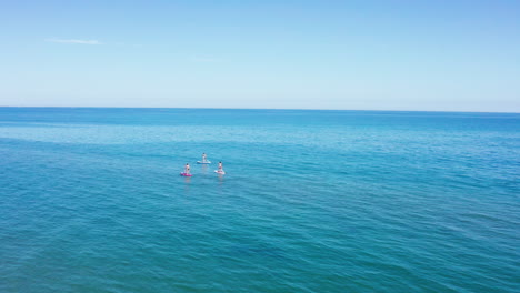 People-doing-paddle-in-the-mediterranean-sea-sunny-day-aerial-shot-France