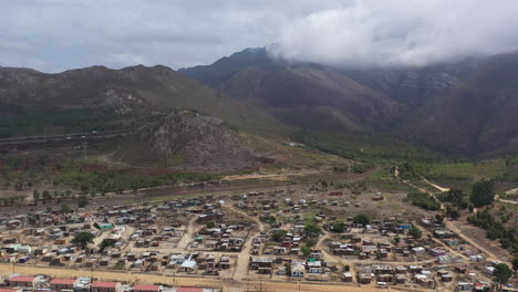 Township-Entlang-Der-Berge-In-Südafrika,-Luftaufnahme-Der-Rückreise