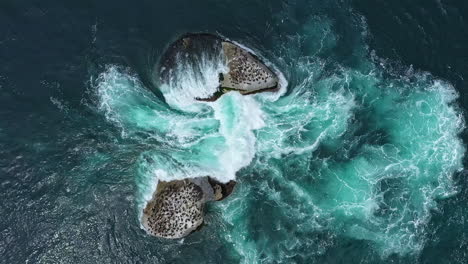 Water-crashing-on-giant-rocks-full-of-birds-in-the-ocean-top-shot-South-Africa