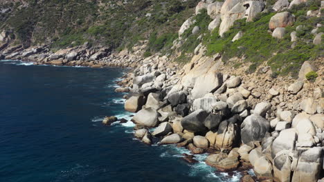 Coastline-Big-rocks-ocean-and-low-vegetation-landscape-aerial-shot