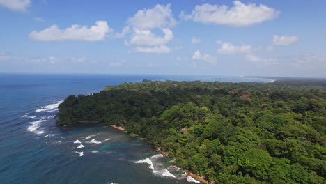 Aerial-spectacle-of-Costa-Rica's-coastline,-where-roaring-waves-meet-golden-sand