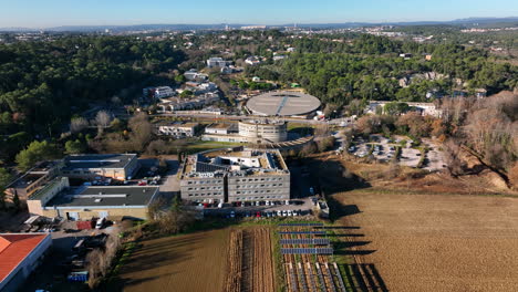 Modern-scientific-modern-buildings-amid-green-fields-aerial-sunny-day