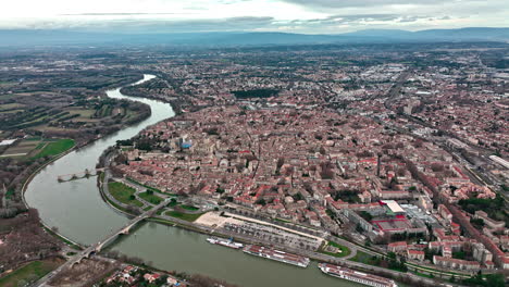 Bird's-eye-view-of-Avignon,-with-clouds-adding-a-touch-of-drama-to-its-skyline.