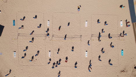 Overhead-capture-of-beachgoers-engaged-in-spirited-volleyball-matches.