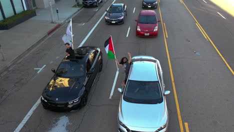 Luftaufnahme-Von-Menschen,-Die-Aus-Autofenstern-Fahnen-Schwenken,-Palästina-Proteste-In-La