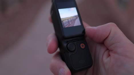 Nahaufnahme-Des-In-Der-Hand-Gehaltenen-DJI-Osmo-Pocket-3-Und-Des-Bildschirms,-Der-Vom-Vertikalen-In-Den-Querformatmodus-Umgedreht-Wird