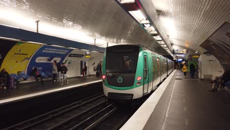 A-Paris-Metro-Train-Transportation-Leaves-Inside-Place-de-Clichy-Station,-France-with-People-Walking-By