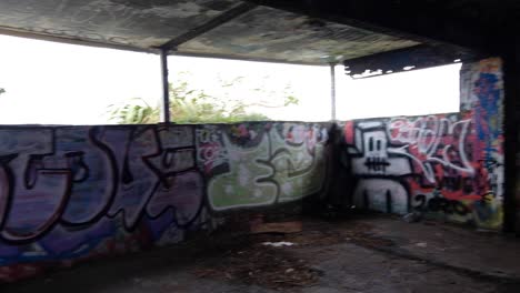 Walking-into-graffiti-covered-WW2-bunker-in-Oruaiti,-previously-known-as-Fort-Dorset-at-Breaker-bay-in-Wellington,-New-Zealand-Aotearoa