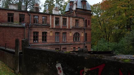 Old-historical-building-in-Tartu-on-Toome-hill,-drone-flight-during-autumn-when-leaves-fall-and-trees-are-colorful