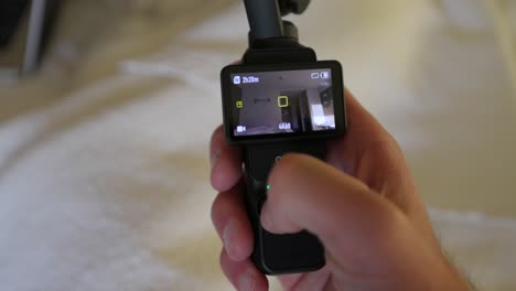 Dji-Osmo-Pocket-3-Sostenido-En-La-Mano-Y-La-Interfaz-De-Pantalla-En-Uso