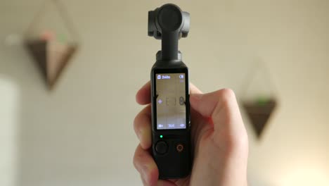 Close-Up-View-Of-DJI-Osmo-Pocket-3-Held-In-Hand-And-Screen-Being-Flipped-From-Vertical-To-Landscape-Mode-And-Turning-Gimbal-Head