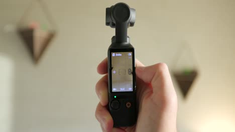 Nahaufnahme-Des-In-Der-Hand-Gehaltenen-DJI-Osmo-Pocket-3-Und-Des-Bildschirms,-Der-Vom-Vertikal--In-Den-Querformatmodus-Umgedreht-Wird-Und-Den-Gimbal-Kopf-Dreht