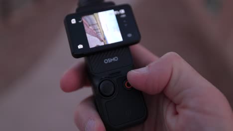 Nahaufnahme-Des-In-Der-Hand-Gehaltenen-DJI-Osmo-Pocket-3-Und-Des-Bildschirms,-Der-Vom-Vertikalen-In-Den-Querformatmodus-Umgedreht-Wird