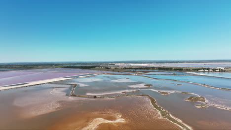 Aerial-spectacle-of-Aigues-Mortes,-where-saline-basins-bloom-in-radiant-pink.
