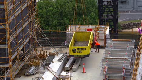 Close-up-shot-capturing-a-superdeck-retractable-crane-loading-platform-descending-downward-with-construction-worker-adjusting-the-landing-position-at-the-site