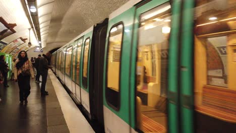 Primer-Plano-Frontal-Del-Tren-De-Metro-Que-Llega-A-La-Estación-Hoche-Paris,-La-Gente-Entra-Por-Puertas-Automáticas