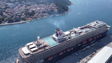 Mein-Schiff-luxury-cruise-ship-disembarking-passengers-to-shuttle-buses-at-port-Gruz