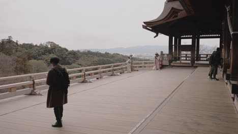 Junger-Asiatischer-Tourist-Auf-Einer-Holzterrasse-Und-Genießt-Die-Schöne-Aussicht-Vom-Kiyomizudera-Tempel-In-Kyoto,-Japan