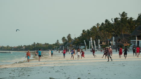 Beach-scene-with-people-and-kite-surfers-at-sunset