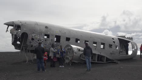 Tourists-explore-Iceland-DC-3-plane-wreckage,-Sólheimasandur-black-sand