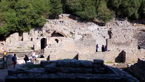 Neugierige-Touristen-Erkunden-Den-Antiken-Schatz-Des-Amphitheaters-Von-Butrint,-Einer-Faszinierenden-Archäologischen-Stätte