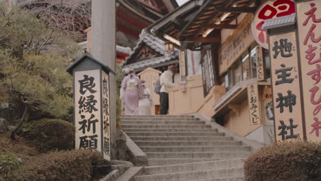 Young-Asian-girls-in-kimono-walking-up-the-staircase-of-Jishu-Jinja-Shrine-in-Kiyomizudera-Temple-in-Kyoto,-deserted-with-no-tourists-during-COVID-19-pandemic