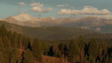 Cinematic-aerial-drone-opener-first-snow-on-Denver-Mount-Blue-Sky-Evans-14er-peak-early-autumn-fall-beautiful-golden-yellow-morning-sunrise-day-Colorado-Rocky-Mountains-pan-down-motion