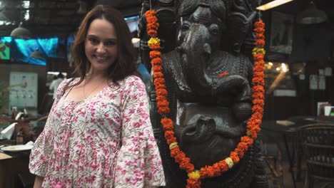 An-Indian-woman-immersed-in-prayer-to-Ganapati-also-known-as-Ganesha,-the-Hindu-god,-on-the-bustling-local-streets-of-Panaji,-Goa,-India-on-31-08-2023