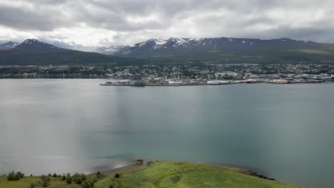 Explora-Akureyri-En-Vívidos-4k,-Una-Joya-Islandesa-Enmarcada-Por-Picos-Nevados-Y-Aguas-Serenas,-Capturada-Por-Un-Dron.
