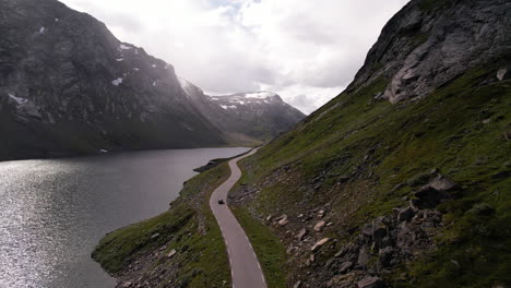 A-car-drives-along-the-serpentine-road-to-Geiranger-by-Lake-Langvatnet