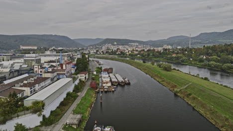 Decin-Czechia-Aerial-v1-drone-flyover-industrial-zone-capturing-ship-barges-docked-on-the-riverbank,-cityscape-along-Elbe-river-and-hillside-landscape-views---Shot-with-Mavic-3-Cine---November-2022