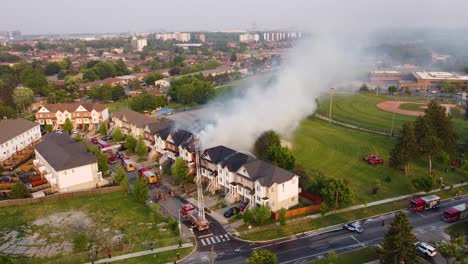 Aerial-Circle-Shot-Firefighters-Working-Hard-to-put-out-Fire-on-a-Townhouse-Smoke-Cover-Scream