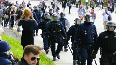 Police-Intervention-Group-Walking-on-the-Sidewalk-With-Citizens-Watching-Anti-G7-Protests