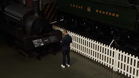 static-shot-of-a-tourist-reading-signs-at-The-National-Railway-Museum-In-York