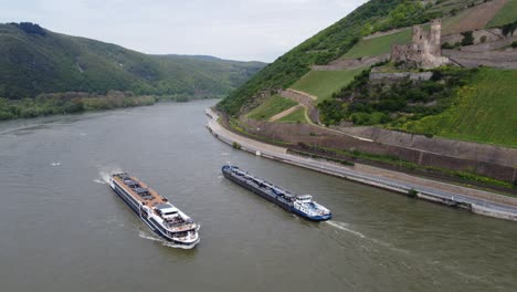 Cruise-ship-and-industrial-tanker-barge-navigating-past-Ehrenfels-Castle-on-river-Rhine,-Germany