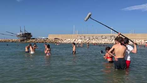 Film-troupe-bathing-in-water-filming-scene-of-boys-and-girls-playing-in-sea-in-summer-season-for-film-production