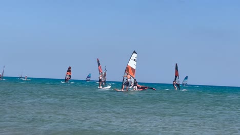 Crowded-ocean-with-many-windsurfer-holding-their-sail,-dutch-angle,-summer-day
