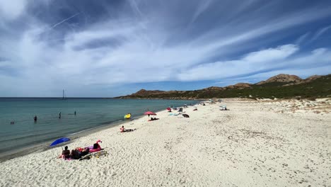 Gente-Bañándose-Y-Tomando-El-Sol-En-La-Arena-Blanca-De-La-Playa-De-Lotu-En-La-Temporada-De-Verano,-Isla-De-Córcega-En-Francia