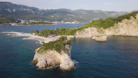 Rocky-coast-with-cliffs,-attractive-Island-Sveti-Nikola,-Budva,-Montenegro,-aerial-view