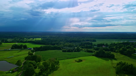 Eine-Atemberaubende-Und-Belebende-Luftaufnahme-Zeigt-Ein-Von-üppigem-Grün-Umgebenes-Dorf-Unter-Einem-Majestätischen,-Mit-Wolken-Geschmückten-Himmel