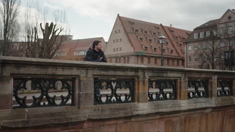 Lone-Man-overlooking-Alstadt,-Nuremberg's-historic-buildings,-Germany