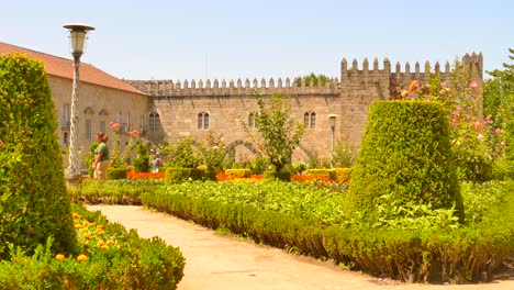 Touristen,-Die-An-Einem-Sonnigen-Tag-Im-Garten-Des-Bischofspalastes-Spazieren---Braga,-Portugal