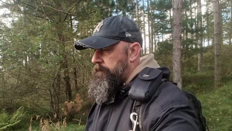 Slow-Motion-Of-Bearded-Man-With-Baseball-Cap-Trekking-In-Heart-Of-Nature,-Anglesey