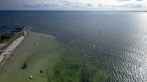 Kitesurf-Y-Windsurf-Se-Elevan-A-Través-De-La-Playa-Y-El-Agua-Frente-A-La-Costa-De-Kuznica,-Polonia